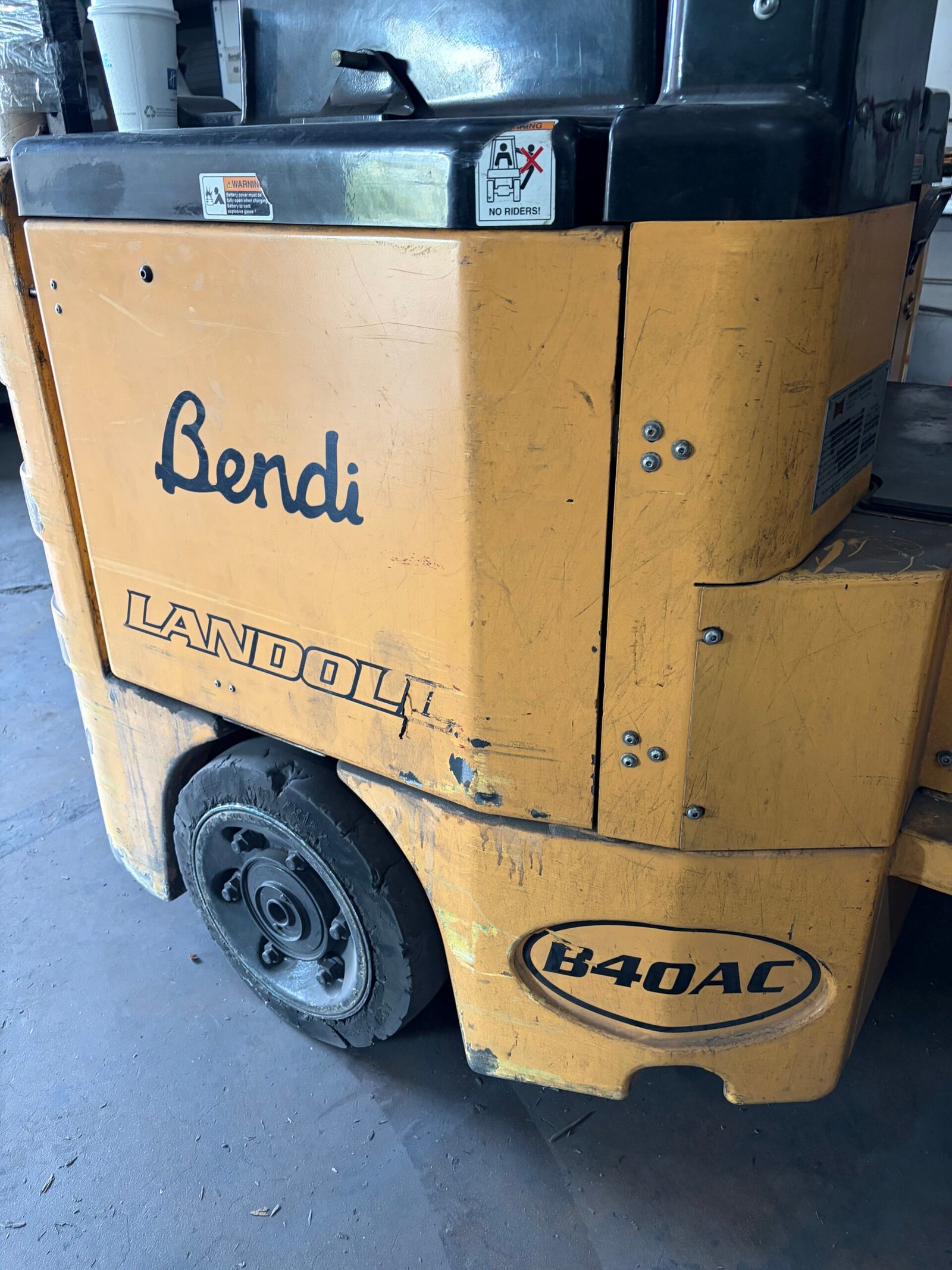 Close-up of the Bendi B40AC side panel and rear tire, showing the used forklift's visible wear.